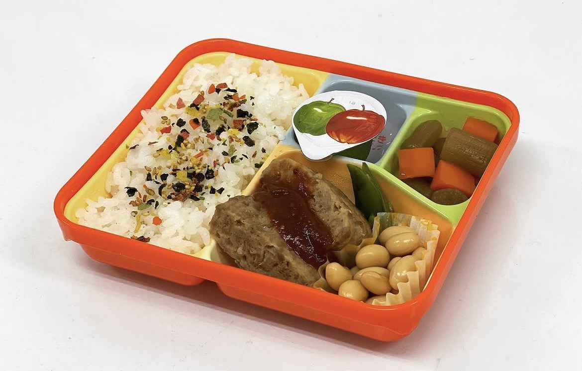 ご飯、ハンバーグ、野菜、豆のおかずを盛り合わせた彩り弁当